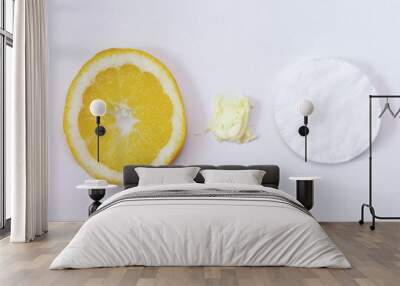 Refreshing cream for skin care, lemon and cotton pads on a light background Wall mural