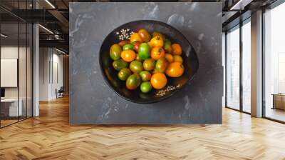 small yellow and green tomatoes in a black dish Wall mural