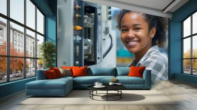 Smiling young female engineer operating machinery in a tech environment Wall mural