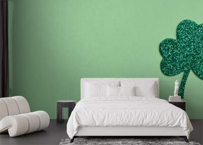 St Patricks Day celebration. Shiny Clover on light green background. Top view, flat lay, copy space, banner Wall mural