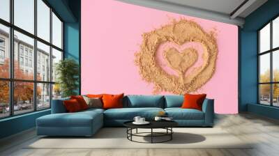 Top view of heart shape made of raw maca root powder on soft pink background with copy space Wall mural