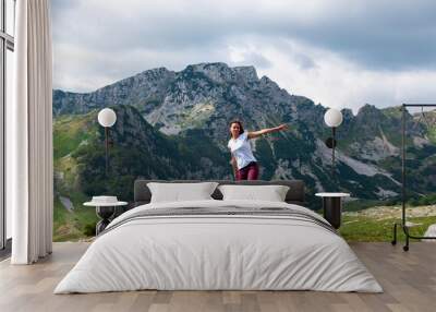 two long hair girls happy jump in mountains with exciting view of Montenegro, Durmitor, back view Wall mural