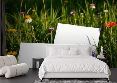 two pieces of paper are in a field of flowers. Wall mural