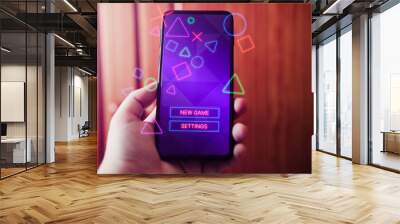 Female hand showing smartphone with gaming interface on screen. Playing online concept with empty space for text. Online entertainment and gamification. Wall mural