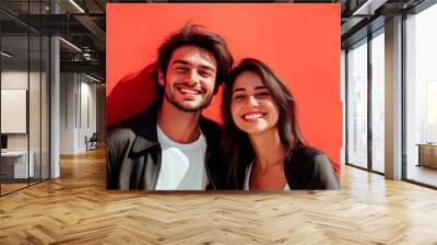 Portrait of cheerful young couple isolated over red background and empty space for text. Wall mural