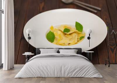 Plate of ravioli with basil on dark background Wall mural