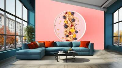 Smoothie bowl with pomegranates, blueberry and granola on a pink background. Tasty and healthy Breakfast. Top view.  Wall mural