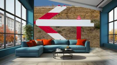 Wooden road sign on the road. Pedestrian route arrow sign direction sign. A wooden arrow indicates the route of movement with a place for an inscription. Follow the wooden arrow. Direction of arrow Wall mural