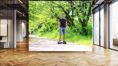 man riding electrical scooter, hoverboard, gyro scooter, gyroboard, smart balance wheel - personal portable eco transport Wall mural