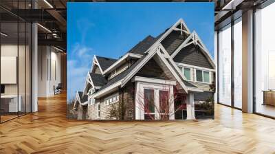 Roof shingles on top of the house against blue sky. Dark asphalt tiles on the roof background, black shingles, roof tile Wall mural