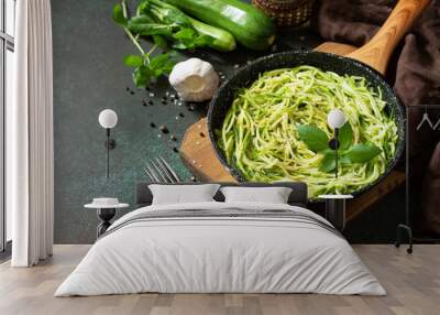 Healthy vegan food, low carb dish. Cooked zucchini noodles with basil and garlic in a cast iron pan on a stone countertop. Copy space. Wall mural