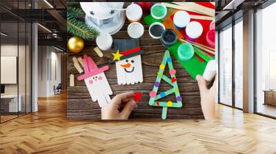 The child glues the parts Christmas decoration or Christmas gift - Snowman, fir-tree and Santa. Handmade. Project of children's creativity, handicrafts, crafts for kids. Wall mural