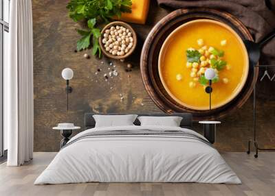 Vegetarian pumpkin and chickpea cream soup on a rustic wooden table. Comfort food, fall and winter healthy slow food concept. View from above. Copy space. Wall mural