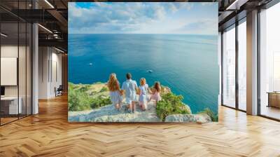 A full family of four mom dad and two daughters all together on a mountaintop above the sea. Wall mural