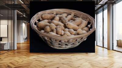 peanuts in a wicker basket on a black background Wall mural