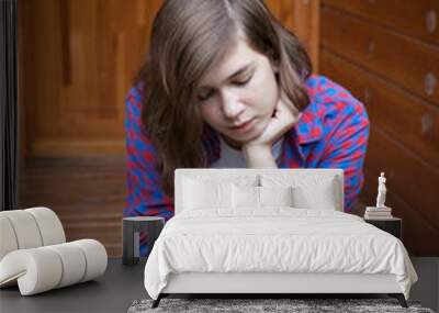 cute teenage girl sitting on the bleacher steps with a serious expression Wall mural