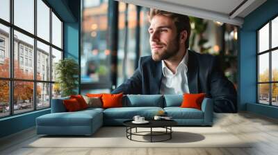 Portrait of a young male executive seated at his office desk. Wall mural