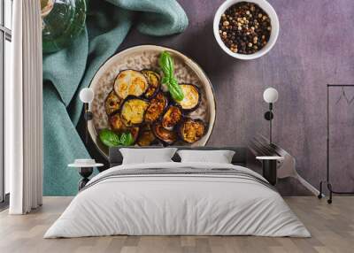 Appetizing fried eggplant with spices and herbs on a plate on the table top view Wall mural