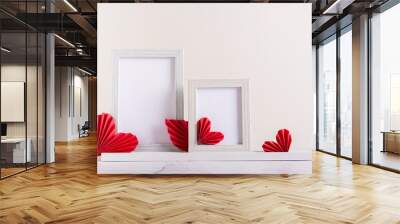 Two blank photo frames decorated with DIY paper hearts. Home decor. Wall mural