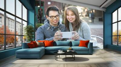 two young people with smartphone in cafe Wall mural