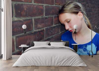 young girl near brick wall looking upset Wall mural