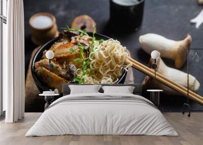 Noodles with eringi mushrooms in a black plate Wall mural