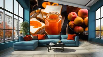 Ripe apricot jam in a glass jar on the table. Wall mural