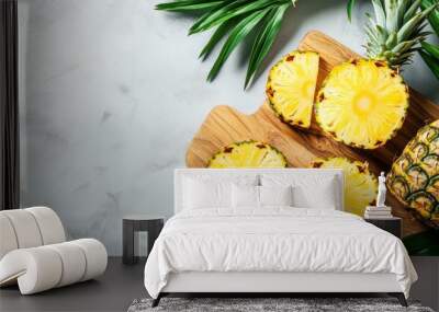 Fresh pineapple slices on wooden cutting board with leaves Wall mural