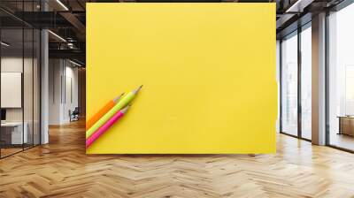 Bright colored pencils on yellow background. Copy space Wall mural