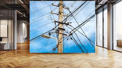 power line post with multiple wires, close-up against blue sky Wall mural