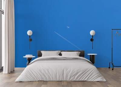 Two passenger aircraft flying nearby. Condensation trail from an airplane in a blue sky. Wall mural