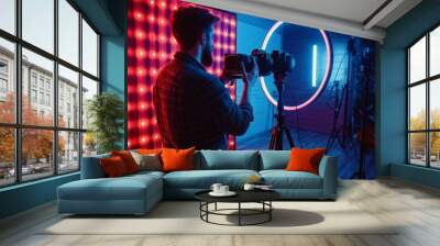 A content creator is capturing engaging content in a dynamic studio setup, surrounded by colorful lighting elements that enhance the atmosphere Wall mural