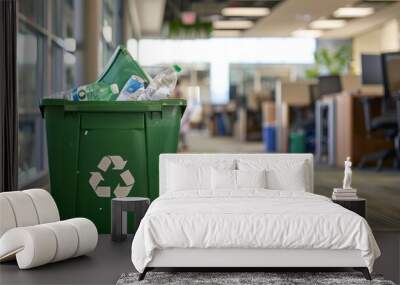 A green recycling bin filled with paper, plastic, and aluminum waste sits in a corporate office hallway, emphasizing the need for proper waste disposal Wall mural