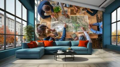 A group of people sitting around a table, studying a map carefully during an urban planning meeting Wall mural