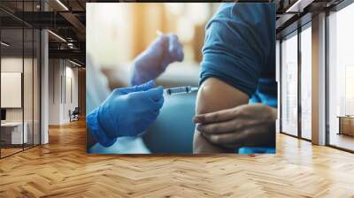 A healthcare provider in blue gloves gives a vaccination to an individual in an inviting clinic environment. The procedure underscores public health efforts Wall mural