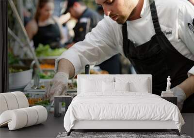 A man in a chefs uniform is seen preparing food in a buffet line at a food festival or culinary event Wall mural