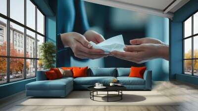 In a bright, contemporary environment, one person hands a folded piece of paper to another, capturing a moment of connection and communication Wall mural