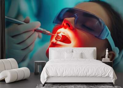 patient lies back as a dental professional uses a laser tool for an oral procedure Wall mural