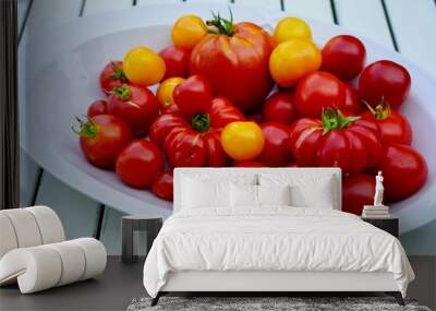 Big white ceramic plate full of fresh large red and orange tomatoes Wall mural