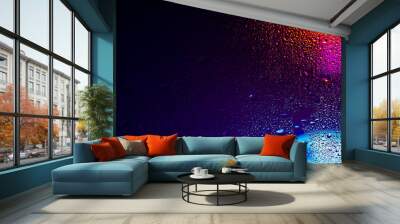 Drops of condensate on the sweaty glass. Cold foggy glass on background night lights Wall mural