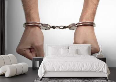 Man's hands in handcuffs on a white background, isolated Wall mural