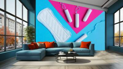 women pads and tampon - sanitary pads lies next to a tampon on an isolated background on a pink and blue background. Wall mural