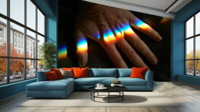 Male hand palm fingers with rainbow crossing on a dark background closeup Wall mural