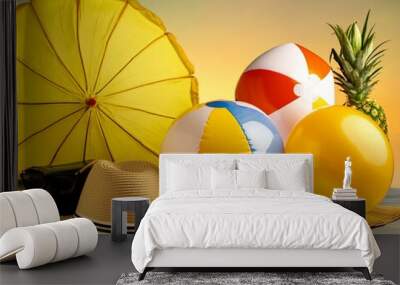 A yellow umbrella, a straw hat, and two beach balls are on a table Wall mural