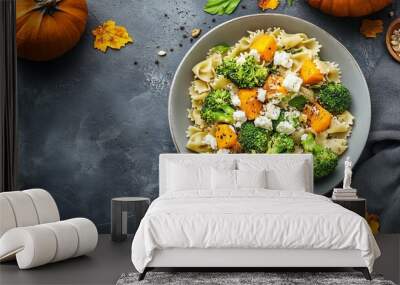 Autumnal pasta salad with roasted pumpkin, broccoli, and feta adorns a light gray backdrop, showcasing the vibrant flavors of the fall season. Wall mural