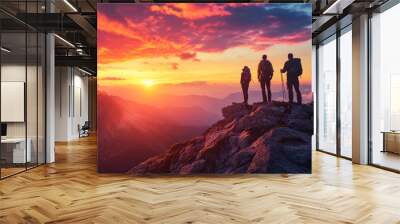 Hikers of all backgrounds stand on a mountain summit, gazing at the sunset's vibrant hues. Wall mural