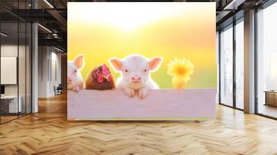 A cute group of baby farm animals looking over a wooden fence.  Wall mural