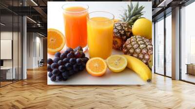 A glass of orange juice with a variety of fruit surrounding it. Wall mural