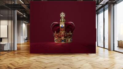 Golden crown on a velvet cushion on a deep red background with copy space Wall mural