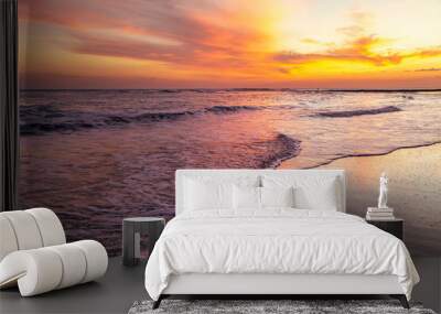 Serene sunset at Playa El Tunco, El Salvador, with gentle waves reflecting vibrant orange and pink hues. A tranquil seascape capturing the peaceful beauty of this popular coastal beach destination. Wall mural